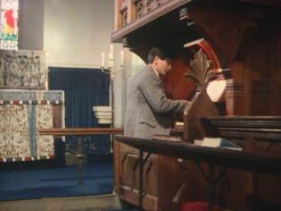 Why Didn’t They Ask Evans? Article Photo - James Warwick as Bobby Jones, the son of the Vicar, “playing” the St Nicholas’ Church organ