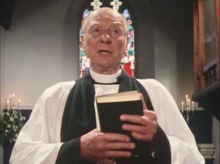 Why Didn’t They Ask Evans? Article Photo - A close-up of Sir John Gielgud in the church.  Peggy Cattell recalls that she received quite a glare from him when she accidentally burst in on him during make-up
